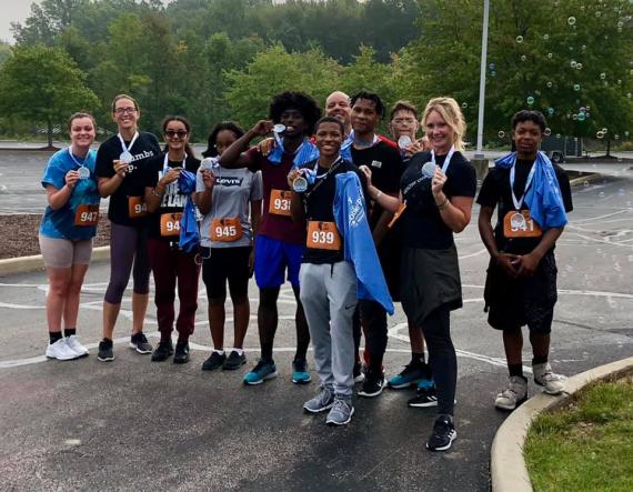 We Run This City Program Director Jessica Schmidt with youth athletes after completing the North Royalton YMCA’s Bubble Blast 5k in September.