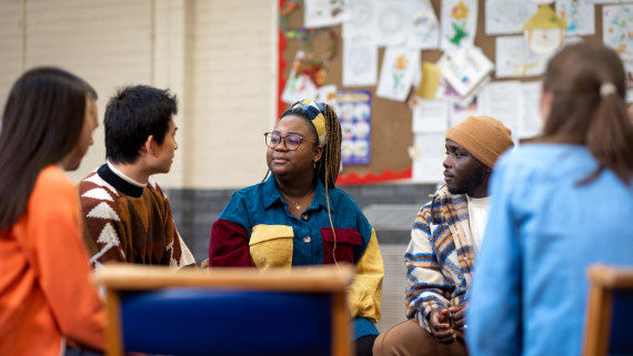 Group of people in a support group, listening attentively.