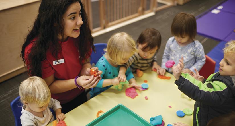 YMCA staff member engaging a group of kids in an activity 