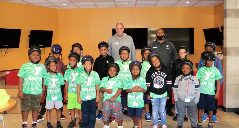 Group photo of YMCA campers wearing bike helmets