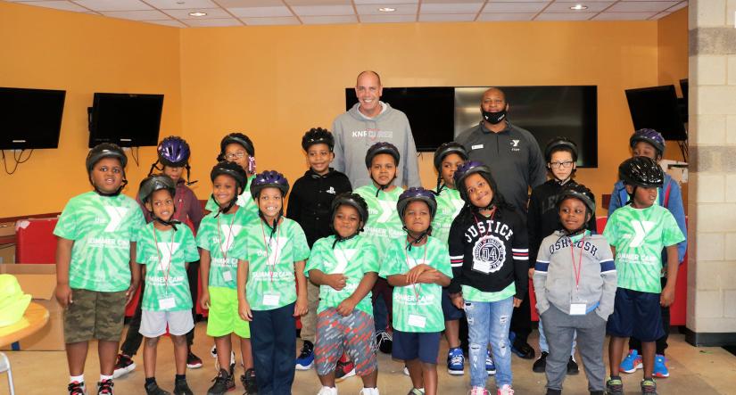 Group photo of YMCA campers wearing bike helmets 