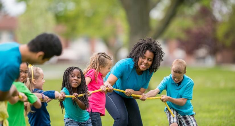 Counselors and campers playing tug of war 