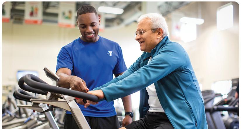 Personal Trainer guiding member on an exercise machine 