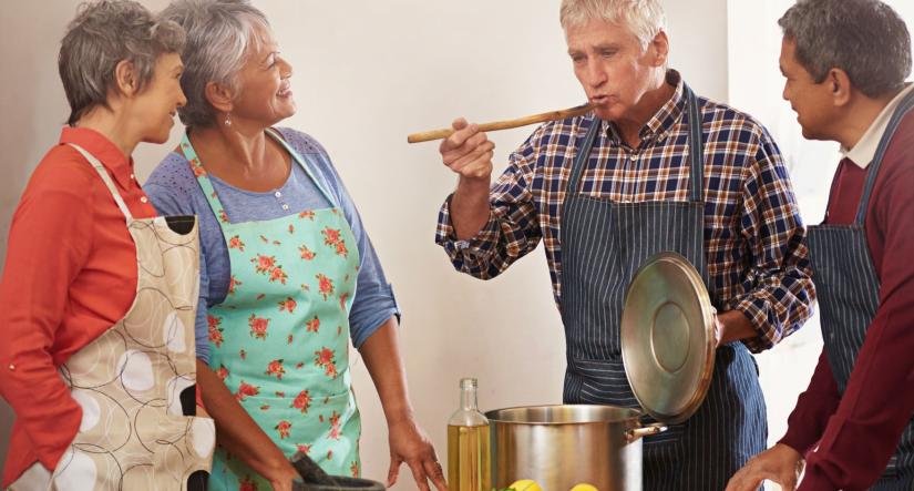 4 senior-aged people cooking together