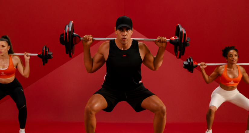 3 people using free weights and squatting. red background
