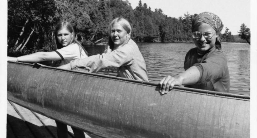 Women holding a canoe at Camp Menogyn