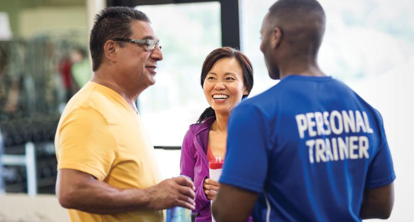 YMCA personal trainer talking with two members