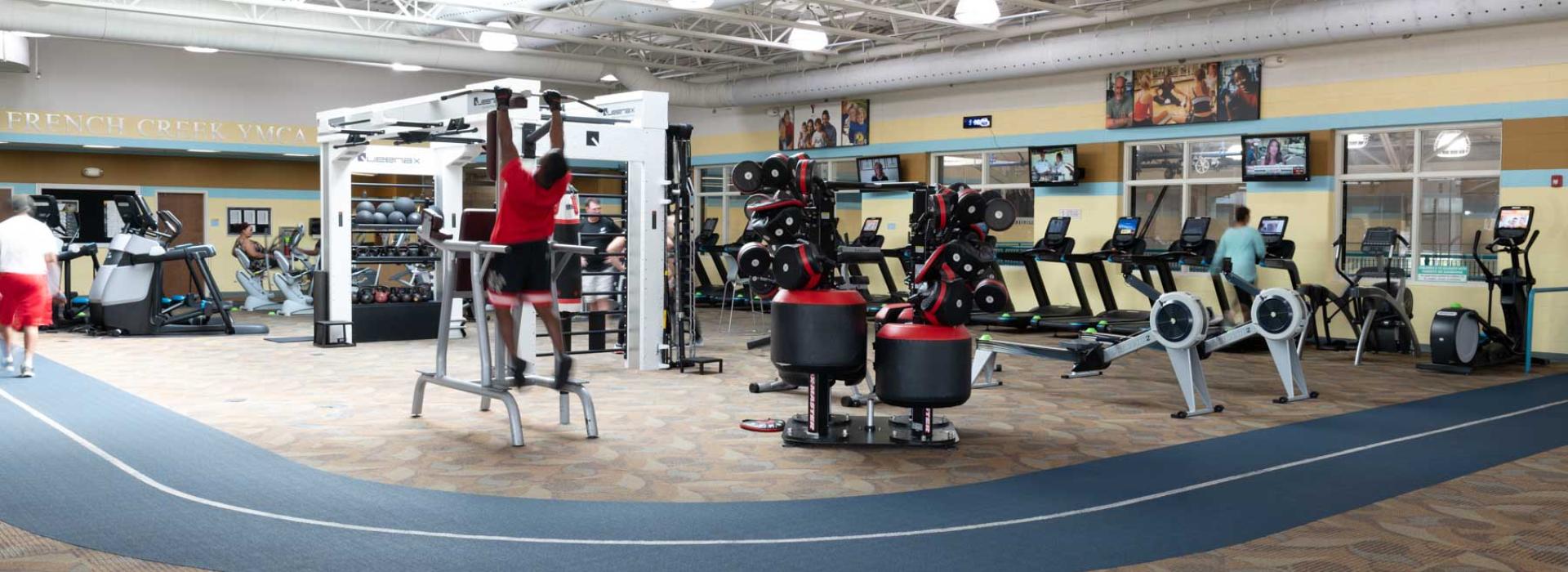 Weight room with indoor walking track. Shows a variety of exercise equipment.